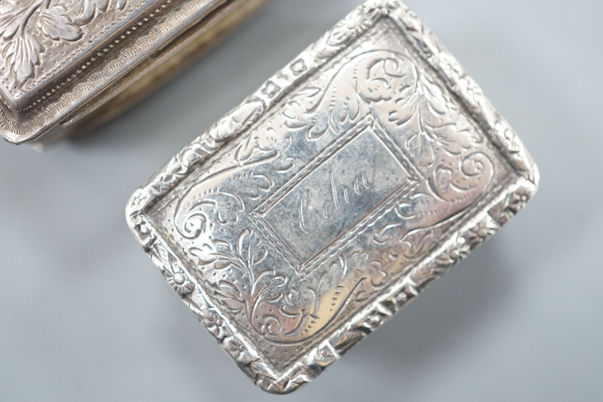 A George IV engraved silver rectangular vinaigrette, by Nathaniel Mills, Birmingham, 1827, engraved 'Celia', 31mm and a later vinaigrette, Birmingham, 1833.